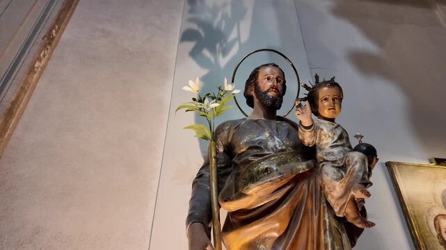 A serene statue of Saint Joseph holding the infant Jesus