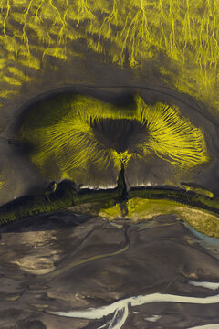 Aerial view of a surreal landscape, where vibrant green vegetation punctuates the dark, winding riverbeds, creating an otherworldly tableau, Highlands Of Iceland, Sveitarf&eacute;lagio Hornafjorour, Iceland.