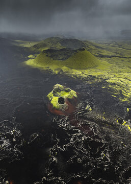 Aerial view of a stark volcanic landscape where vibrant green moss clings to black lava fields under a brooding sky, Highlands Of Iceland, Sveitarf&eacute;lagio Hornafjorour, Iceland.