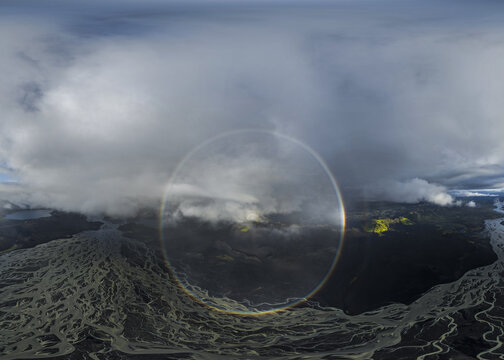 Aerial view of glacial rivers weaving through a stark, volcanic landscape, a ghostly Brocken spectre floating amidst the moody clouds, Highlands Of Iceland, Sveitarf&eacute;lagio Hornafjorour, Iceland.