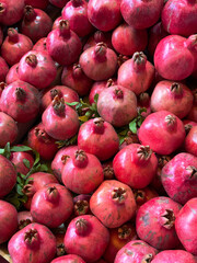 Fresh ripe pomegranates with vibrant red skin and green leaves