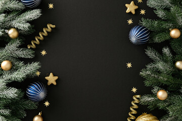 Luxury Christmas flat lay composition with frosted pine branches, gold and blue bauble, glitter star and ribbon on black background. Xmas banner design, New Year greeting card template