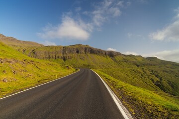 black asphalt highway in the mountainous coastal countryside of the Faroe Islands