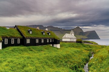 traditional sod-roof wooden houses and the historic church in Vidareidi on Vidoy in the Faroe Islands