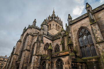Fototapeta premium Upward view of the upper portion of St Giles’ Cathedral in Edinburgh, highlighting its beautiful Gothic architecture and intricate stonework from the 14th century