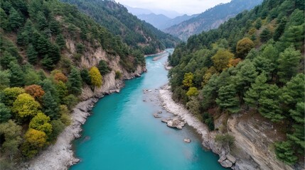 Drone Captures Expansive Mountain Valley With A Bright Turquoise River Flowing Through Lush Green Trees And Rocky Shores Under A Cloudy Sky