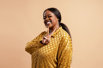 Confident Black woman making peace sign, smiling