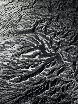 Aerial view of a dramatic landscape carved by nature's hand, revealing an intricate tapestry of textures and tones, Mount Bromo, East Java, Indonesia.