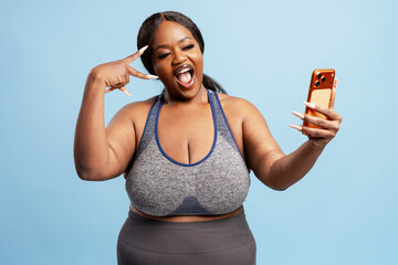 Happy African American woman taking selfie with smartphone