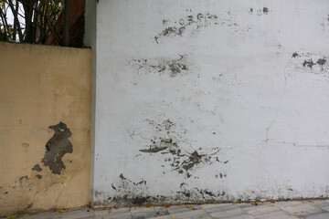 Texture of a brick wall with old, peeling paint in some partially ruined buildings