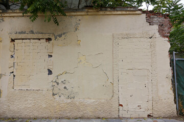 Texture of a brick wall with old, peeling paint in some partially ruined buildings