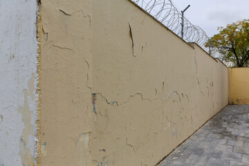 Texture of a brick wall with old, peeling paint in some partially ruined buildings