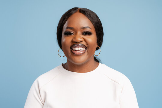 Young black woman expressing joy on blue background