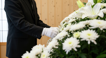 白い手袋で供花を整える葬儀スタッフ