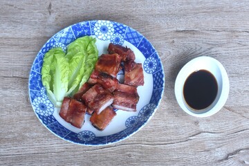 fried crispy pork bone or rib with baby cos lettuce on plate dipping black sweet sauce cup