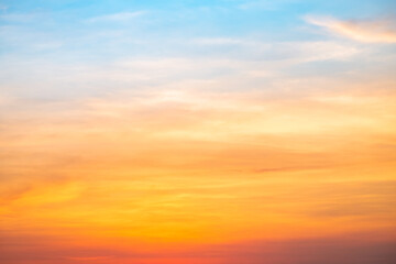 Sunset or sunrise sky with a vibrant gradient of orange, gold, and soft blue. Clear atmosphere with wispy clouds. Peaceful, natural light background. hope, freedom, new day and inspirational Concepts