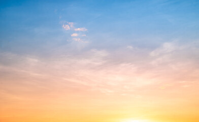 Sunset or sunrise sky with a vibrant gradient of orange, gold, and soft blue. Clear atmosphere with wispy clouds. Peaceful, natural light background. hope, freedom, new day and inspirational Concepts