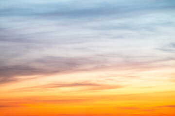 Sunset or sunrise sky with a vibrant gradient of orange, gold, and soft blue. Clear atmosphere with wispy clouds. Peaceful, natural light background. hope, freedom, new day and inspirational Concepts