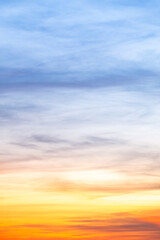 Sunset or sunrise sky with a vibrant gradient of orange, gold, and soft blue. Clear atmosphere with wispy clouds. Peaceful, natural light background. hope, freedom, new day Concepts, Vertical