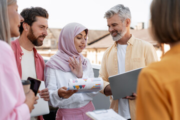 Diverse group of colleagues working talking, planning project, beautiful woman wearing stylish hijab