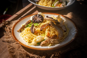 A rustic vegetarian noodle dish served with shiitake mushrooms, set amidst warm natural light, perfect for promoting vegan, Asian, food menus and healthy lifestyle concepts.