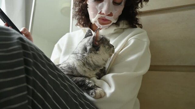 Young woman sitting and hugging a cat