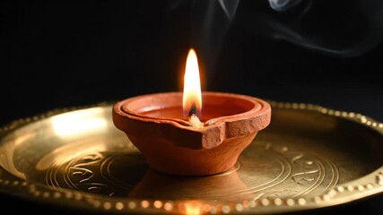 traditional clay diya lamp lit on brass plate - Powered by Adobe
