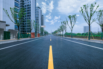 Empty asphalt road and modern residential apartment buildings in a new development district.