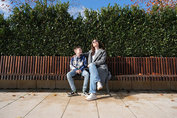 Fototapeta premium boy and his mother sitting on a park bench talking