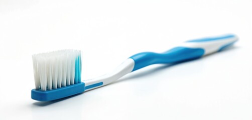 Close up studio shot shows blue toothbrush with white bristles on white background. Tool for daily teeth cleaning, health care. Dental hygiene product for oral cavity protection. Dentist promotional