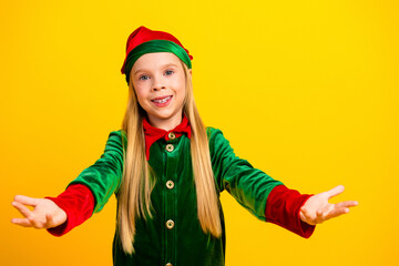 Happy child in elf costume spreads joy against a yellow background, embodying the festive Christmas spirit with endless cheer