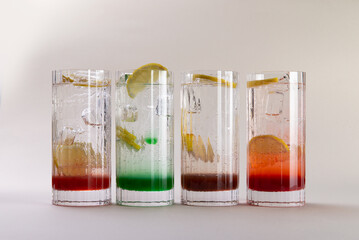 Sparkling water with various syrups in glasses.
