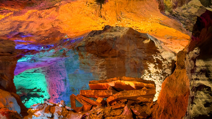Illuminated Cave Interior with Multicolor Lights on Rock Formations