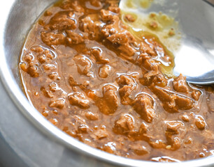 Wet cat food with spoon in a aluminium bowl.