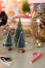 Cookie jar, tea, wine, nuts, books, lit candles and Christmas decorations on the table. Cozy Christmas hygge at home. Selective focus.
