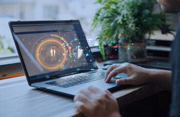 Person using laptop with futuristic digital interface displaying data security icons, representing online protection, information privacy, and network safety technology.
