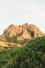 Sunlit Mountain Peak Over Lush Greenery - A Natural Landscape.