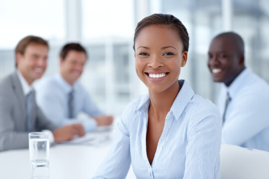 Confident businesswoman smiling during meeting with diverse colleagues in bright modern office setting
