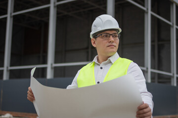 Holding a blueprint. Engineer at a construction site. High quality photo
