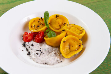 Ravioli on a plate. On a green background.