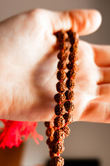 Japamala from Rudraksha on the hand. Prayer beads. Religious equipment	
