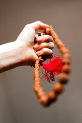Japamala from Rudraksha on the hand. Prayer beads. Religious equipment	
