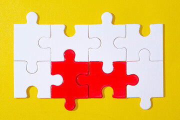 Fototapeta premium eight elements from jigsaw puzzle with two element is red on yellow background. concept for unity