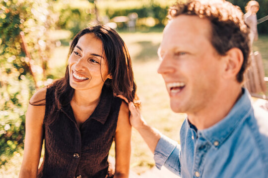 Happy male and female friend spending leisure time with each other in back yard