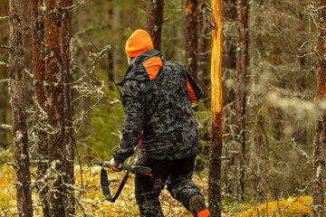 Hunter with his hunting rifle outdoor in the autumn wilderness hunting moose