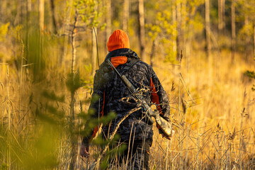 Hunter with his hunting rifle outdoor in the autumn wilderness hunting moose