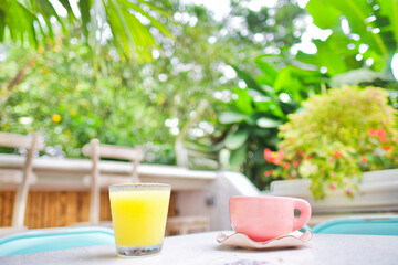 Very light breakfast with only an orange juice and a cup of coffee on a terrace outside in the famous neighborhood 