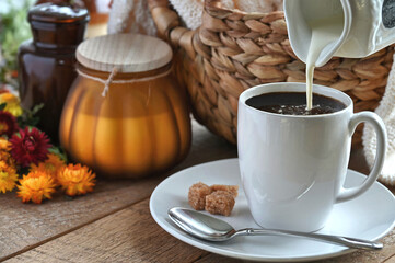 Pouring cream or milk into hot coffee or tea