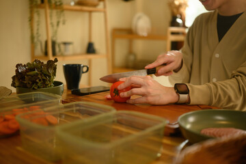 Close-Up of Hands Cutting Carrots for a Healthy Meal in a Cozy Home Kitchen