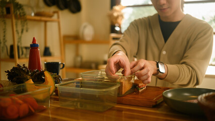 Hands Packing Homemade Sandwiches for a Lunchbox in a Kitchen
